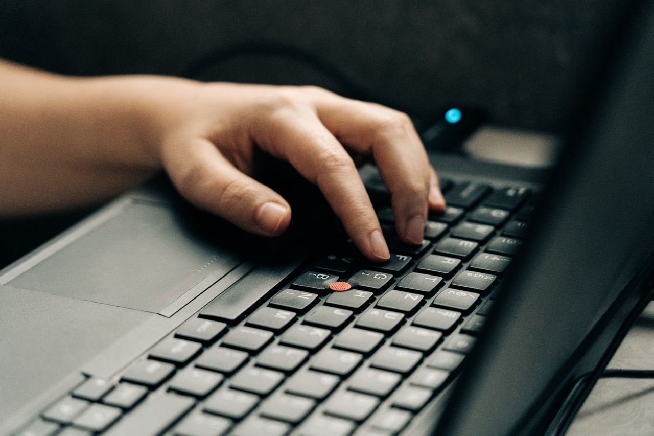 A hand typing on a laptop keyboard. Perfect for technology and business themes.